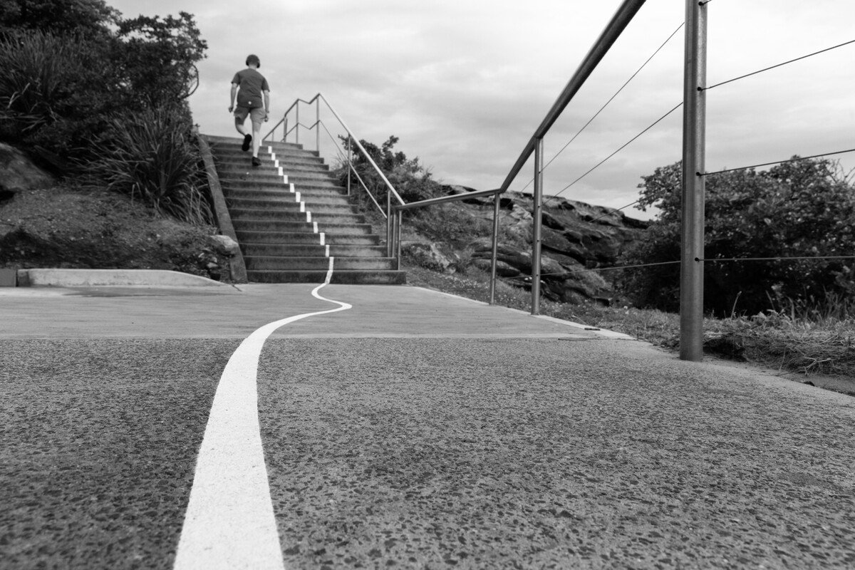 A figure walking up stairs, the white line running through the frame.